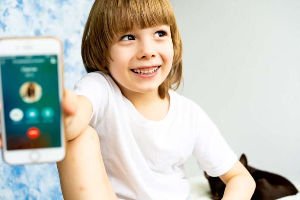 A little boy with a mobile phone, telephone communication in messengers, modern children, gadgets